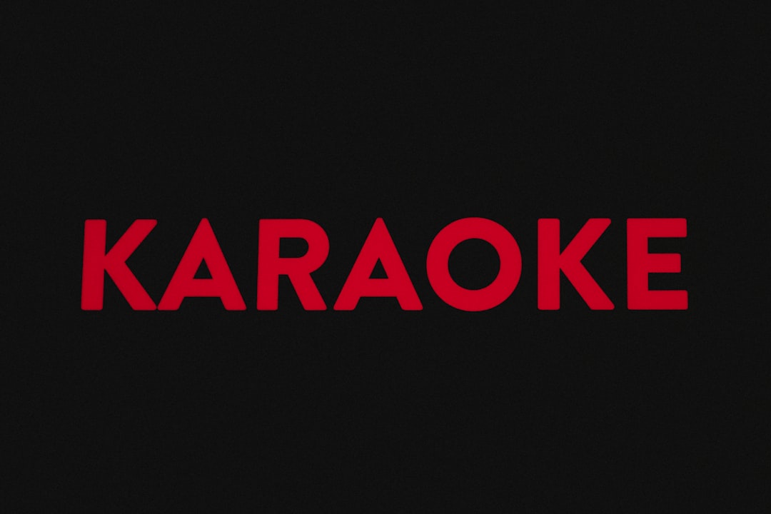 A red karaoke logo on a black background — Foto por Samuel Regan-Asante na Unsplash