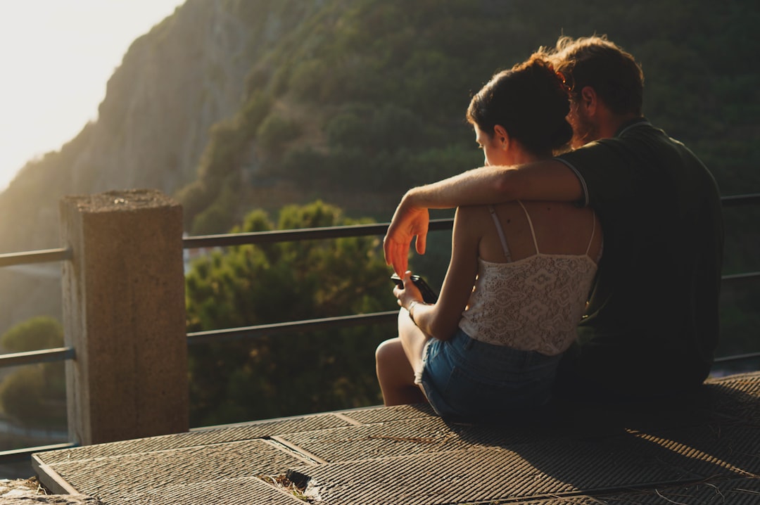 man and woman sitting on concrete surface — Foto por Eugeniya Belova na Unsplash