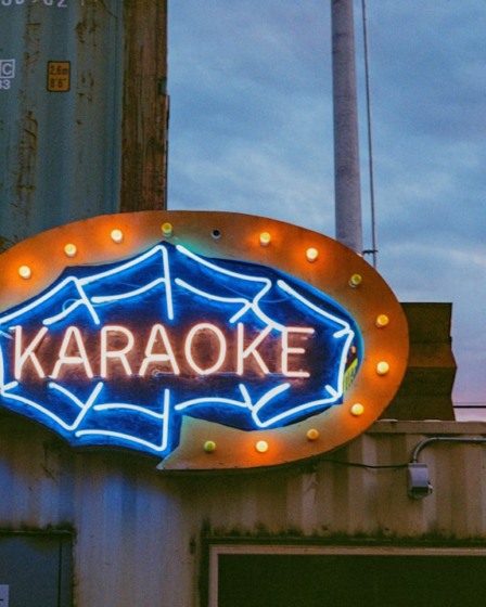 a large neon sign on the side of a building — Foto por Nikola Đuza na Unsplash