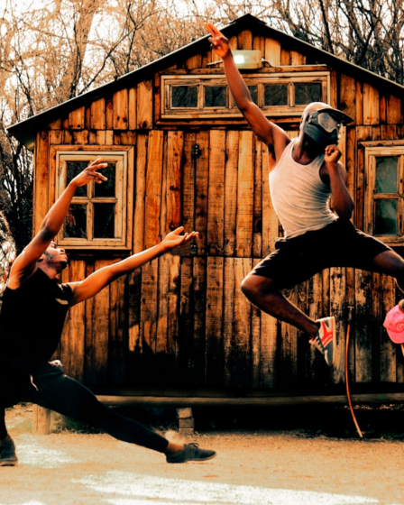a couple of people playing frisbee in front of a log cabin — Foto por Jamal Selolwane na Unsplash