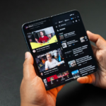 Hands holding a folding smartphone displaying youtube — Foto por Amanz na Unsplash