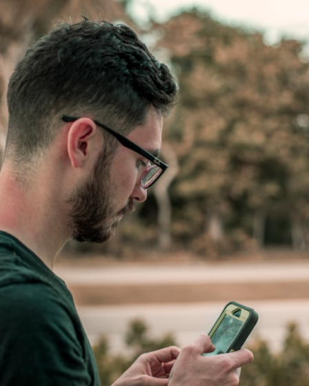 man looking down on his phone — Foto por Jacob Townsend na Unsplash