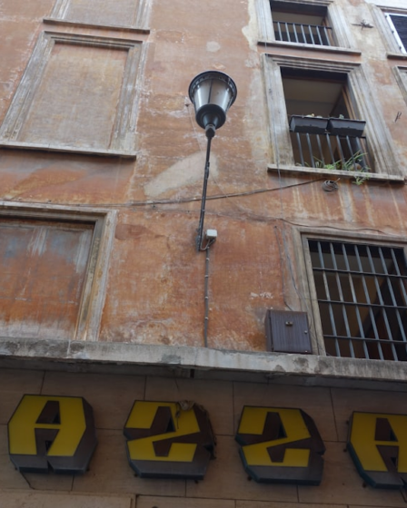 Old building facade with a street lamp and signage — Foto por MChe Lee na Unsplash