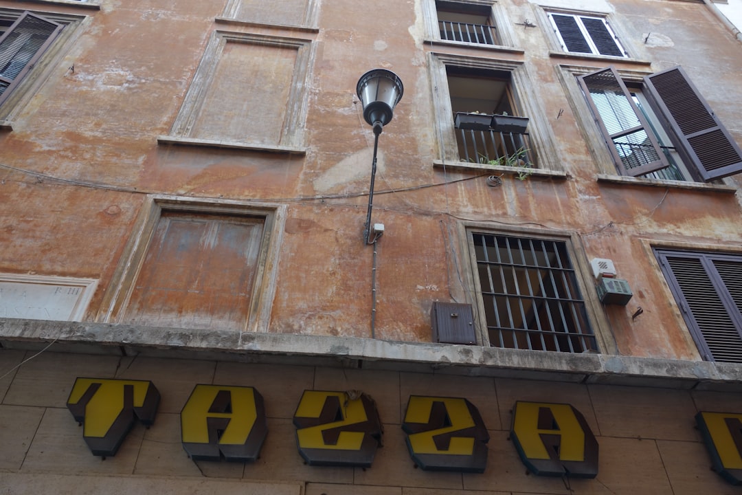Old building facade with a street lamp and signage — Foto por MChe Lee na Unsplash