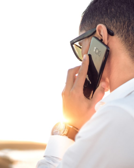 man holding smartphone standing in front of calm body of water — Foto por Hassan OUAJBIR na Unsplash