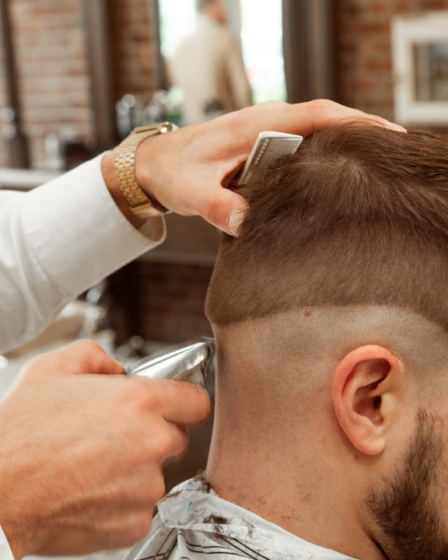 man in white dress shirt cutting hair of man — Foto por Michael DeMoya na Unsplash