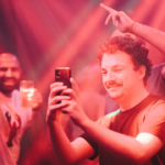 a man taking a picture with his cell phone — Foto por peter bucks na Unsplash